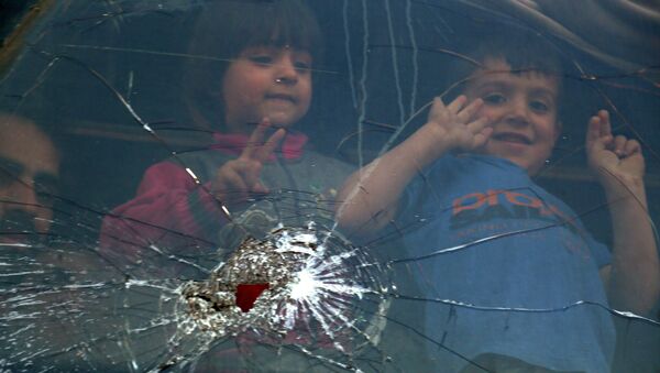 Crianças olham pela janela de um ônibus perto da cidade de Al-Bab, norte da Síria, depois que os combatentes e suas famílias foram retirados da cidade de Douma, 3 de abril de 2018 - Sputnik Brasil