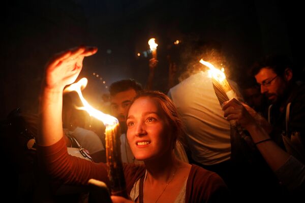 Crentes seguram velas para participar da tradicional cerimônia ortodoxa do Fogo Sagrado, na Basílica do Santo Sepulcro, em Jerusalém - Sputnik Brasil