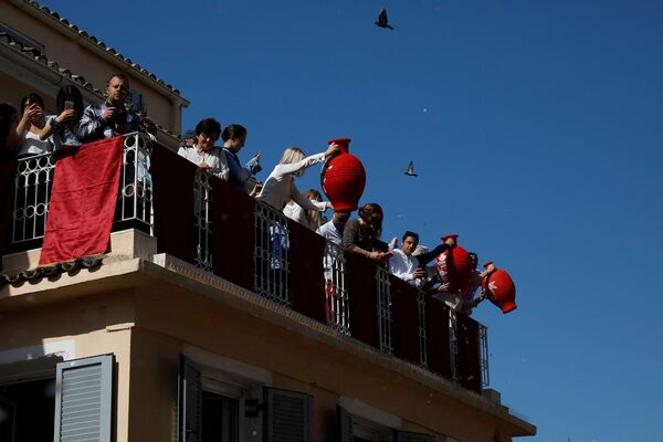 Pessoas se preparam para jogar fora potes de barro de janelas no âmbito da tradição grega de Botides, no Sábado Santo, na Grécia - Sputnik Brasil