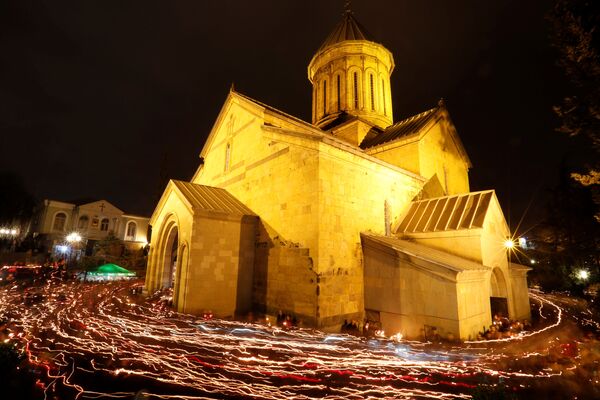 Crentes andam perto da Catedral de Sioni com velas acesas após a missa pascal, em Tbilisi, na Geórgia - Sputnik Brasil