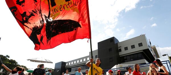 Apoiador do ex-presidente Lula segura bandeira com rosto do petista em Curitiba - Sputnik Brasil