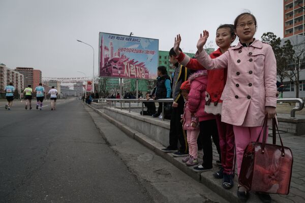 Crianças saúdam participantes da maratona anual em Pyongyang, 8 de abril de 2018 - Sputnik Brasil