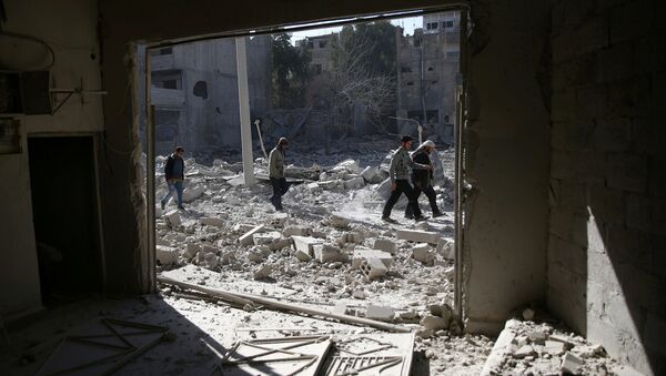 As pessoas andam em uma área atingida por ataques aéreos no bairro rebelde de Douma sitiada de Damasco, na Síria. (Arquivo) - Sputnik Brasil