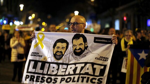 Em Barcelona, na Espanha, um manifestante segura um cartaz com o rosto de Jordi Sanchez, da Assembleia Nacional da Catalunha, e Jordi Cuixart, líder da Omnium Cultural, em apoio aos políticos presos. - Sputnik Brasil