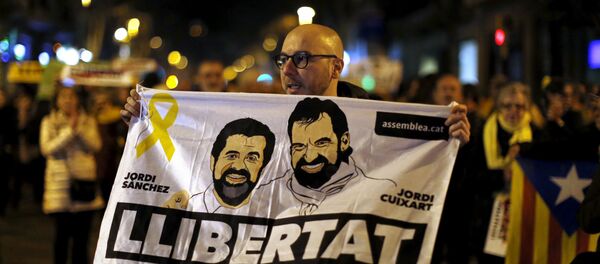Em Barcelona, na Espanha, um manifestante segura um cartaz com o rosto de Jordi Sanchez, da Assembleia Nacional da Catalunha, e Jordi Cuixart, líder da Omnium Cultural, em apoio aos políticos presos. - Sputnik Brasil