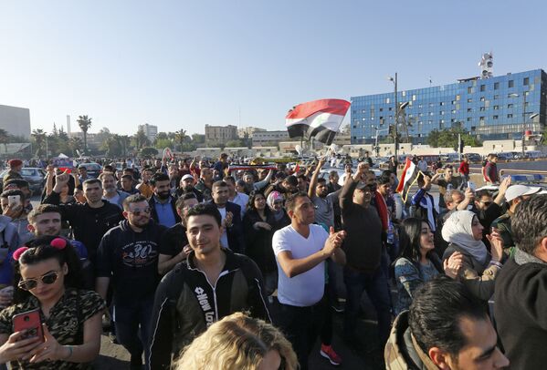 Participantes de uma manifestação contra os ataques aéreos da coalizão internacional na praça Umayyad, em Damasco - Sputnik Brasil