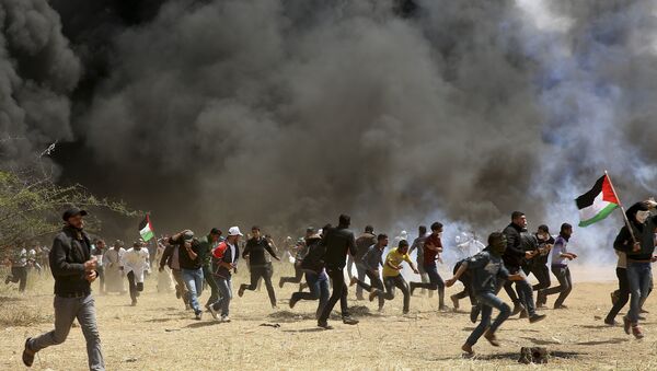 Palestinian protesters run to cover from teargas fired by Israeli soldiers during clashes with Israeli troops along Gaza's border with Israel, east of Khan Younis, Gaza Strip, Friday, April 6, 2018 - Sputnik Brasil