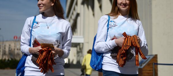 Voluntárias distribuindo fitas de São Jorge em Moscou no âmbito da iniciativa tradicional dedicada ao Dia da Vitória - Sputnik Brasil