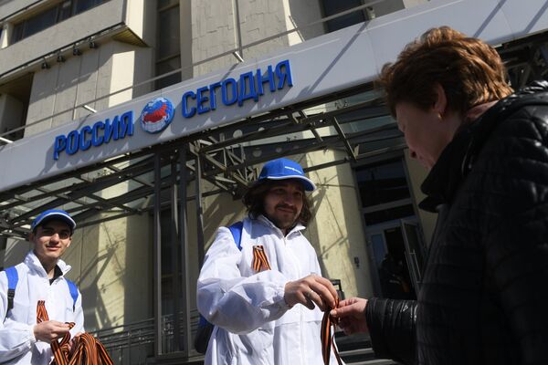Voluntários distribuindo fitas de São Jorge em Moscou em frente à sede da Agência Internacional de Notícias Rossiya Segodnya Voluntários distribuindo fitas de São Jorge em Moscou em frente à sede da Agência Internacional de Notícias Rossiya Segodnya - Sputnik Brasil