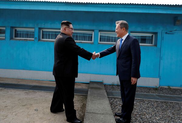 Líderes da Coreia do Norte, Kim Jong-un, e da Coreia do Sul, Moon Jae-in, apertam as mãos durante encontro na localidade de Panmunjom, na zona desmilitarizada que separa os dois países - Sputnik Brasil