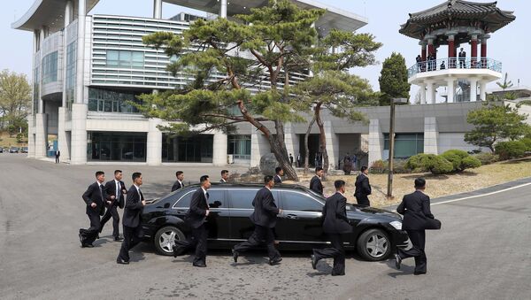 Guarda-costas escoltam o carro do líder norte-coreano, Kim Jong-un, no trajeto de volta à Coreia do Norte durante a pausa para almoço - Sputnik Brasil