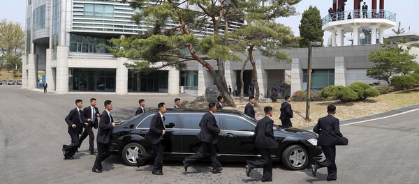 Guarda-costas escoltam o carro do líder norte-coreano, Kim Jong-un, no trajeto de volta à Coreia do Norte durante a pausa para almoço - Sputnik Brasil