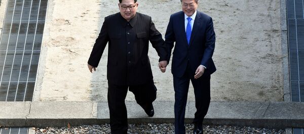 Líder norte-coreano Kim Jong-un e seu homólogo sul-coreano Moon Jae-in atravessam a linha que demarca a zona desmilitarizada na aldeia fronteiriça de Panmunjom, 27 de abril de 2018 - Sputnik Brasil