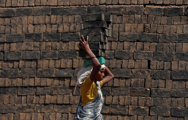 Mulher carrega tijolos sobre sua cabeça na cidade de Mumbai, na Índia - Sputnik Brasil