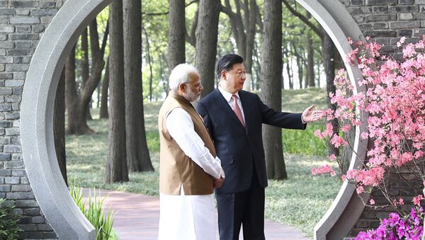 O primeiro-ministro da Índia, Narendra Modi, e o presidente da China, Xi Jinping, conversam em um jardim em Wuhan, China, 28 de abril de 2018 - Sputnik Brasil