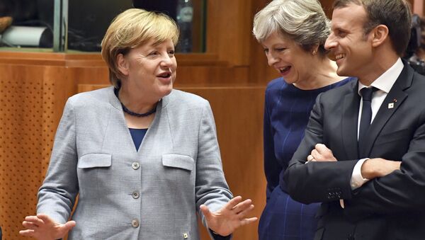 A chanceler alemã, Angela Merkel, à esquerda, fala com a primeira-ministra britânica Theresa May, centro, e com o presidente francês Emmanuel Macron antes de uma mesa redonda em uma cúpula da UE em Bruxelas. - Sputnik Brasil