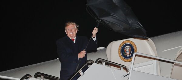 Donald Trump, com o guarda-chuva virado do avesso pelo vento forte, se preparando para descer do Air Force One durante sua visita a base aérea de Andrews (Maryland), 28 de abril de 2018 - Sputnik Brasil