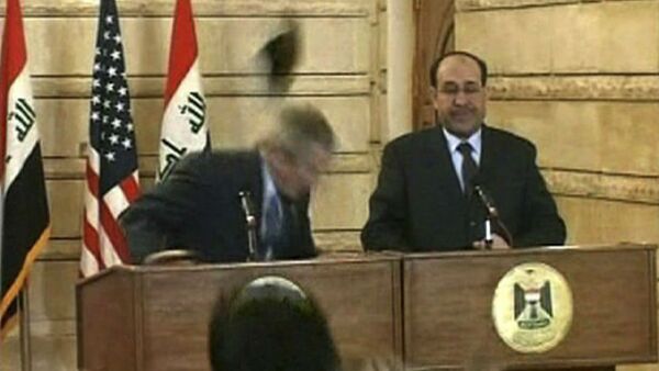 In this image from APTN video, a man throws a shoe at President George W. Bush during a news conference with Iraq Prime Minister Nouri al-Maliki on Sunday, Dec. 14, 2008, in Baghdad. The man threw two shoes at Bush, one after another. Bush ducked both throws, and neither man was hit. - Sputnik Brasil