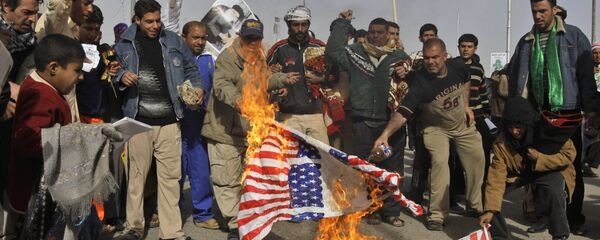 Manifestantes iraquianos queimando as bandeiras dos EUA e de Israel como gesto de apoio à Palestina - Sputnik Brasil
