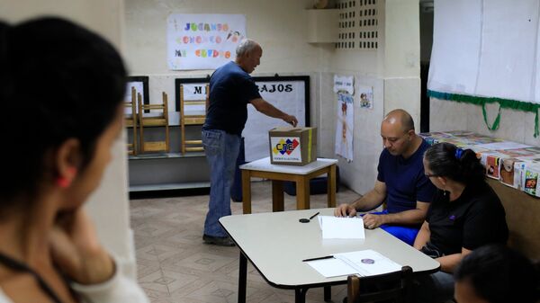 Um venezuelano joga seu voto em uma seção de votação durante a eleição presidencial em Caracas, Venezuela. - Sputnik Brasil