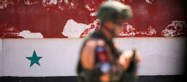 Soldado russo caminhando com a bandeira síria em fundo, Homs, Síria Soldado russo caminhando com a bandeira síria em fundo, Homs, Síria - Sputnik Brasil