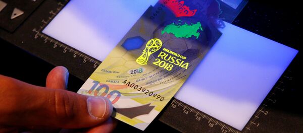 Diretor geral da estatal Arkady Trachuk mostra a marca d'água da cédula de 100 rublos emitida especialmente para a Copa do Mundo de 2018 pelo banco central da Rússia. - Sputnik Brasil