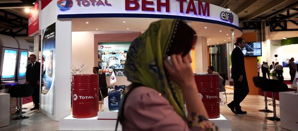 Empresária sul-coreana falando ao telefone em frente à tenda da empresa francesa de óleo e gás Total, durante uma feira internacional de negócios no Irã (foto de arquivo) - Sputnik Brasil