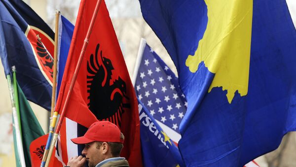 Um homem albanês do Kosovo segura bandeiras em Pristina em 16 de fevereiro de 2011 em preparação para o terceiro aniversário da declaração de independência do Kosovo. - Sputnik Brasil