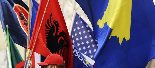 Um homem albanês do Kosovo segura bandeiras em Pristina em 16 de fevereiro de 2011 em preparação para o terceiro aniversário da declaração de independência do Kosovo. - Sputnik Brasil