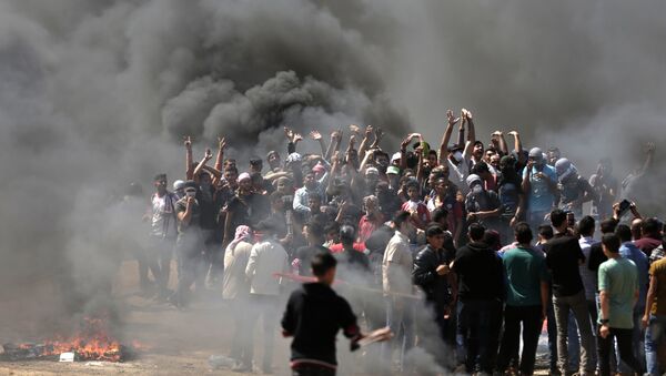 Manifestantes palestinos queimam pneus perto da fronteira entre Gaza e Israel, a leste da cidade de Gaza, enquanto palestinos se preparam para protestos pela posse da embaixada dos Estados Unidos, após a controversa mudança para Jerusalém, em 14 de maio de 2018 - Sputnik Brasil