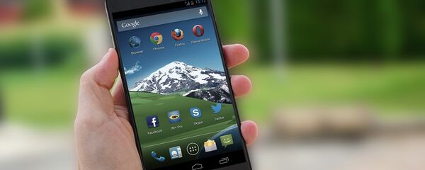 Mão segurando um smartphone com sistema operacional Android - Sputnik Brasil