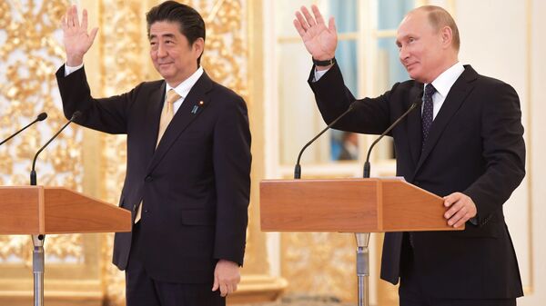 Premiê japonês, Shinzo Abe, e o presidente russo, Vladimir Putin, durante uma ligação de vídeo à tripulação da Estação Espacial Internacional no Kremlin - Sputnik Brasil