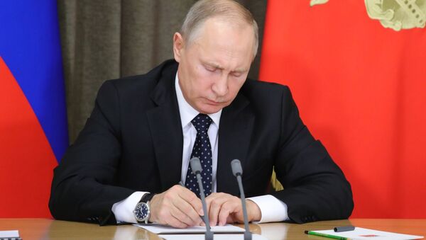 Vladimir Putin assinando um documento durante a reunião dedicada ao reequipamento das Forças Armadas da Rússia, novembro de 2017 (foto de arquivo) - Sputnik Brasil