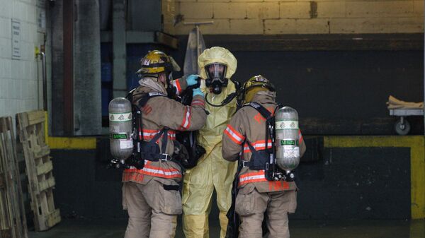 Bombeiros estadunidenses ajudam seu colega que tinha coletado amostras de um objeto que supostamente continha esporos de antraz. Foto de 2012. - Sputnik Brasil