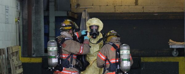 Bombeiros estadunidenses ajudam seu colega que tinha coletado amostras de um objeto que supostamente continha esporos de antraz. Foto de 2012. - Sputnik Brasil
