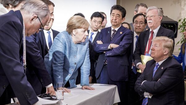 Nesta foto disponibilizada pelo governo federal alemão, a chanceler alemã Angela Merkel fala com os EUA. O presidente Donald Trump é visto sentado à direita durante a Cúpula dos Líderes do G7 em La Malbaie, Quebec, Canadá. - Sputnik Brasil
