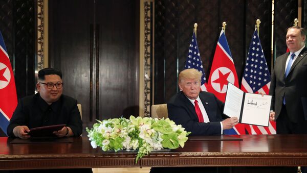 O presidente dos EUA, Donald Trump, mostra o documento assinado com o líder norte-coreano, Kim Jong-un - Sputnik Brasil