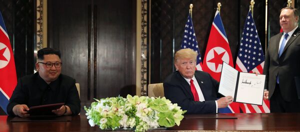 O presidente dos EUA, Donald Trump, mostra o documento assinado com o líder norte-coreano, Kim Jong-un - Sputnik Brasil