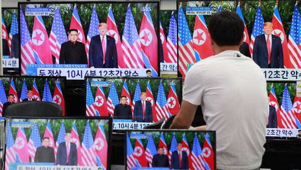 Habitante da capital sul-coreana, Seul, assiste à transmissão da cúpula histórica entre Donald Trump e Kim Jong-un em Singapura, em 12 de junho de 2018 - Sputnik Brasil