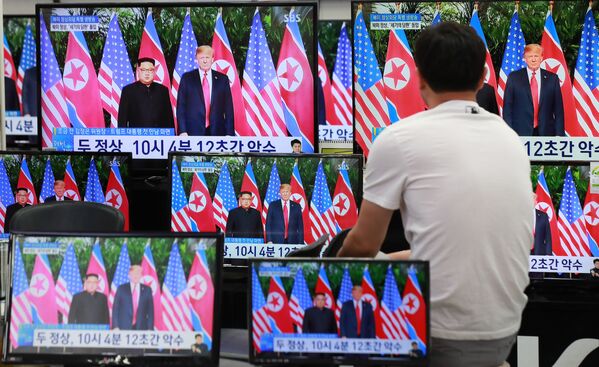 Habitante da capital sul-coreana, Seul, assiste à transmissão da cúpula histórica entre Donald Trump e Kim Jong-un em Singapura, em 12 de junho de 2018 - Sputnik Brasil