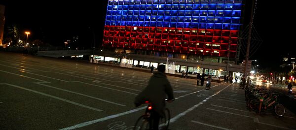 A man rides bicycle across the Tel Aviv city hall building as it is illuminated in solidarity with Russia after the blast in the St.Petersburg metro in Tel Aviv, Israel April 3, 2017 - Sputnik Brasil