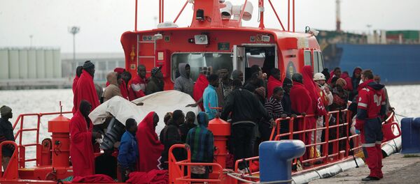 Migrants, who were part of a group intercepted aboard a dinghy off the coast in the Mediterranean sea, stand on a rescue boat upon arriving at a port in Malaga, southern Spain, December 3, 2016 Migrants, who were part of a group intercepted aboard a dinghy off the coast in the Mediterranean sea, stand on a rescue boat upon arriving at a port in Malaga, southern Spain, December 3, 2016 - Sputnik Brasil
