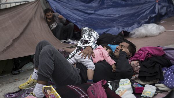 Um pai e uma criança migrantes aguardam fora de um prédio para pedir asilo nos EUA em Tijuana, México. - Sputnik Brasil