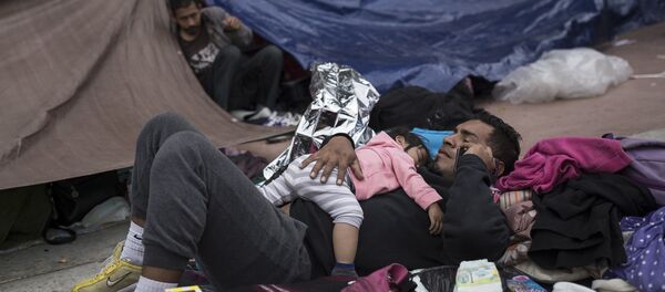 Um pai e uma criança migrantes aguardam fora de um prédio para pedir asilo nos EUA em Tijuana, México. - Sputnik Brasil
