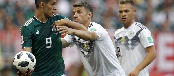 O jogador alemão Thomas Mueller tenta tomar a bola do mexicano Raul Jimenez durante jogo entre as seleções no 1º jogo do grupo F da Copa do Mundo de 2018. - Sputnik Brasil