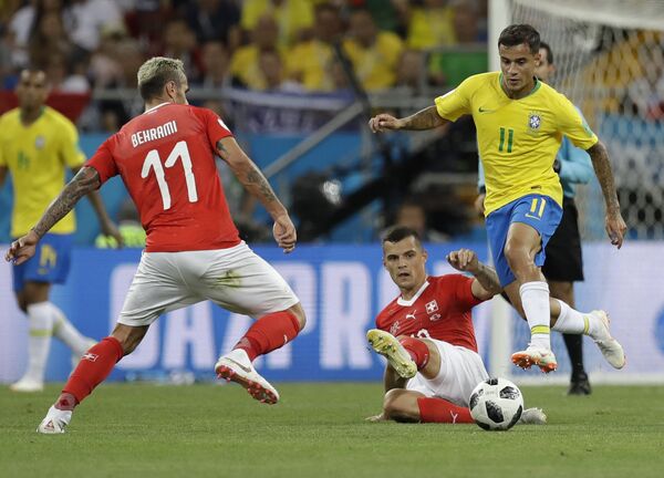 Philippe Coutinho, à esquerda, tenta vencer a marcação de Granit Xhaka, que desliza ao centro e do camisa 11 suíço, Behrami, à direita. O lance é parte do jogo entre Brasil e Suíça na estreia das seleções no grupo E durante a Copa do Mundo de 2018, na Rússia. - Sputnik Brasil