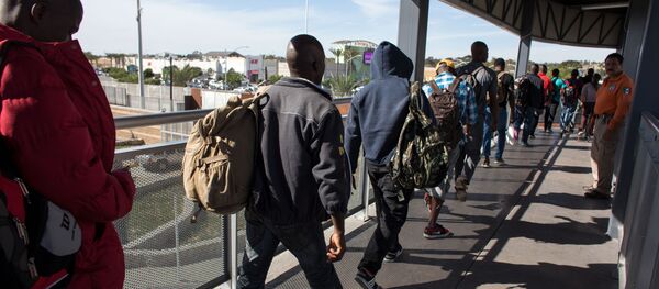 Migrantes haitianos que procuram asilo nos Estados Unidos fazem fila frente a um prédio na fronteiriça cidade mexicana de Tijuana. - Sputnik Brasil