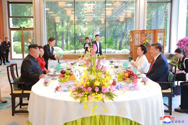 Os líderes da China, Xi Jinping, e da Coreia do Norte, Kim Jong-un, assistem ao almoço conjunto, acompanhados por suas esposas, durante o encontro em Pequim - Sputnik Brasil