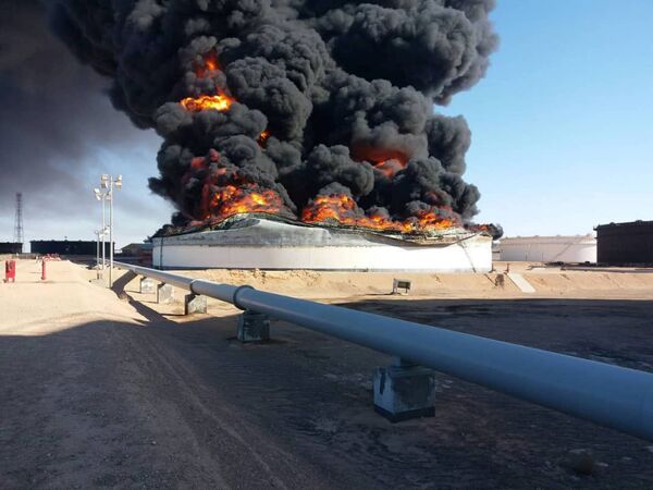 Fumaça e chamas subindo sobre um tanque de armazenamento de petróleo incendiado durante um combate entre grupos rivais em Ras Lanuf, Líbia. - Sputnik Brasil