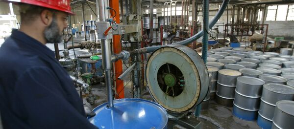 Trabalhador da refinaria de Dura, próximo a Bagdá, enche um barril de petróleo. - Sputnik Brasil